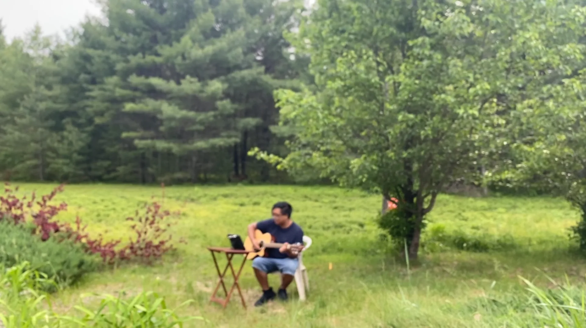User playing guitar with Rocksmith+ on iPad outdoors
