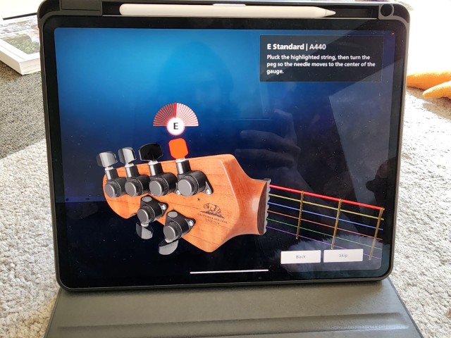 iPad showing Rocksmith+ 3D guitar tuning interface with highlighted E string